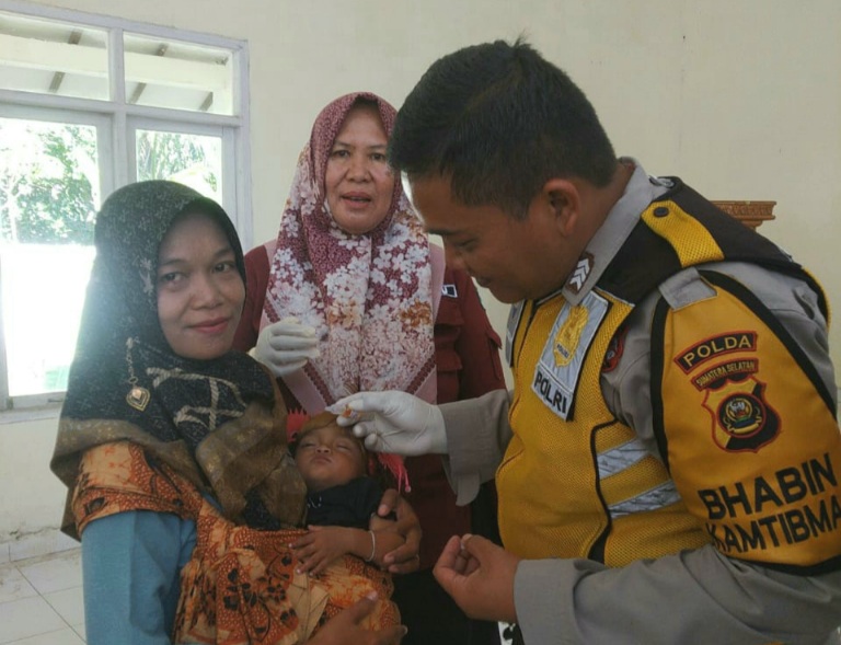 Bhabinkamtibmas Berikan Vaksin Polio Tetes, Sukseskan Pekan Imunisasi Nasional
